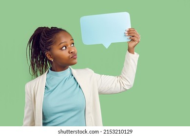 Pensive Young African American Woman Isolated On Green Studio Background Look At Speech Bubble With Mockup Space. Black Girl Think Of Offer Or Deal On Talk Balloon. Copy Space, Advertising.