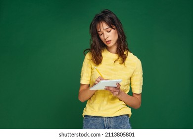 Pensive Young Girl Writing Startup Business Ideas, Plans, Creative Thoughts To Notebook, Make To-do List Not To Forget