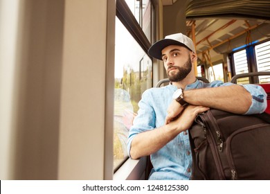 Pensive young hipster man sitting in a city bus. - Powered by Shutterstock