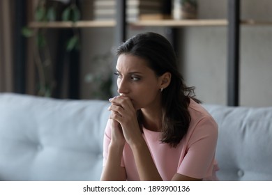 Pensive young indian Arabic woman sit on sofa look in distance thinking or pondering, have personal life problems. Thoughtful millennial ethnic female feel anxious worried. Trouble, stress concept. - Shutterstock ID 1893900136
