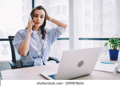 Pensive Young Woman Calling To Operator Of Customer Support Update Software On Laptop Computer In Office,serious Female Freelancer Concentrated On Telephone Conversation About Online Business