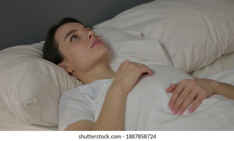 Pensive Young Woman Laying Awake In Bed 