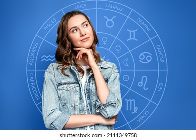 Pensive young woman on the background of the zodiac circle, astrology. Blue background. Predictions, divination - Powered by Shutterstock