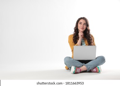 Pensive Young Woman Sitting With Laptop On White Background