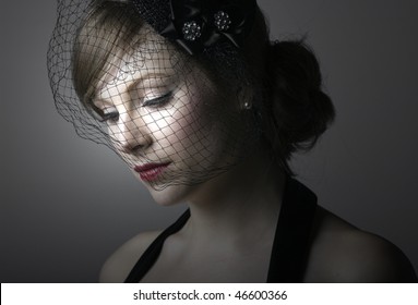 pensive young woman in a veil looks down
