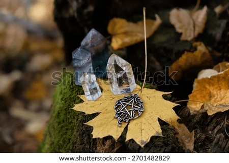 pentacle amulet, quartz crystals, fallen leaves close up on tree stump, autumn forest natural background. minerals for Magic crystal Ritual. Witchcraft, spiritual esoteric ceremony. Lithotherapy.
