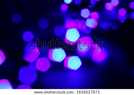 Pentagonal bokeh lights. Black background. Blurred. Celebration decor.