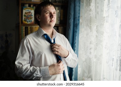 Penza, Russian Federation - April 21, 2017: The groom tightens his tie. A man in a white shirt. Wedding day. 