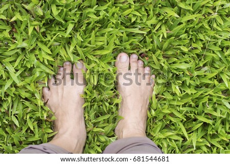 peole feets with grass in the garden