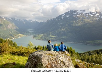 People, adult with kids and pet dog, hiking mount Hoven, enjoying the splendid view over Nordfjord from the Loen skylift