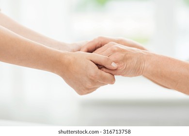 People, Age, Family, Care And Support Concept - Close Up Of Senior Woman And Young Woman Holding Hands