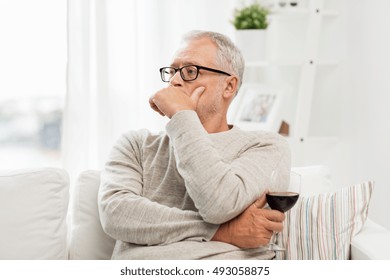 People, Alcohol And Drinks Concept - Senior Man Drinking Red Wine From Glass At Home