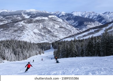 People alpine downhill skiing on trail at Vail ski resort in the Colorado Rocky Mountains in winter - Shutterstock ID 1589555386