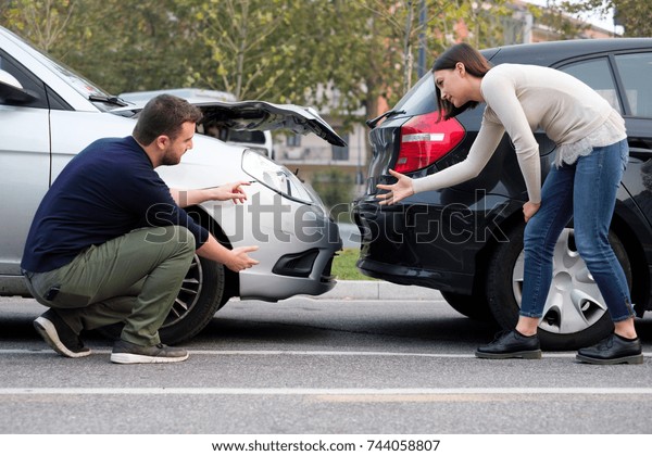 People arguing after a car crash and trying to\
find friendly agreement