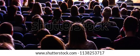 People in the auditorium watching the performance. The audience in the theater.