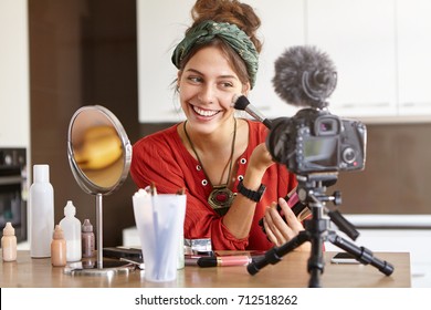 People, Beauty, Fashion And Style Concept. Portrait Of Positive Joyful Young Female Vblogger Recording Video For Her Blog On How To Do Make Up In 5 Minutes, Sharing Beauty Tips And Recommendations