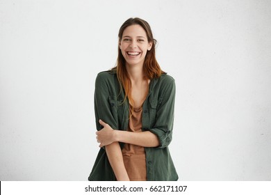 People, Beauty And Lifestyle Concept. Shot Of Attractive Sensual Woman With Wide Smile Dressed In Green Jacket And Brown T-shirt Smiling Broadly Being Happy To Meet Her Best Friend. Joyful Nice Female