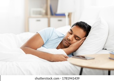 people, bedtime and rest concept - indian man sleeping in bed at home
