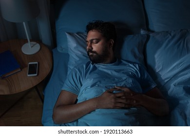 people, bedtime and rest concept - indian man sleeping in bed at home at night - Shutterstock ID 1920113663