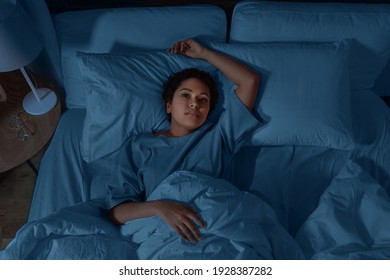 people, bedtime and rest concept - sleepless african american woman lying in bed at night