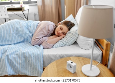 people, bedtime and rest concept - teenage girl sleeping in bed at home in morning