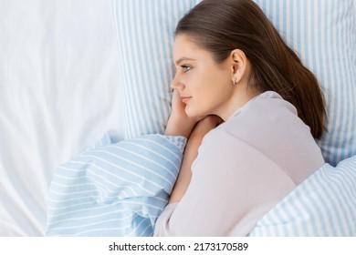 people, bedtime and rest concept - teenage girl lying in bed at home in morning