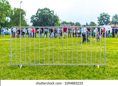 People Behind A Single Metal Barricade At A Village Event