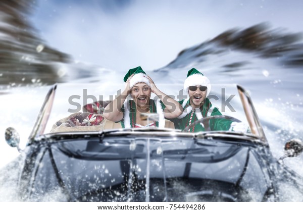 The people in the\
black cabriolet are hurrying for Christmas. Winter road through the\
mountains of the Alps.