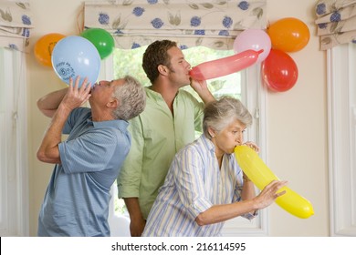 People blowing up birthday balloons