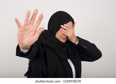 People, Body Language. Young Muslim Woman Covers Eyes With Palm And Doing Stop Gesture, Tries To Hide From Everybody. Don't Look At Me, I Don't Want To See, Feels Ashamed Or Scared.