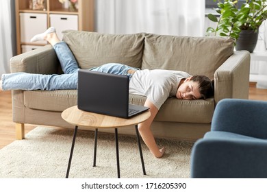 People, Boredom And Depression Concept - Bored Or Lazy Young Woman With Laptop Computer Lying On Sofa At Home