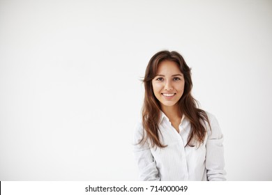 People, Business, Success And Life Goals Concept. Successful Beautiful Young Hispanic Female Entrepreneur In Formal Shirt Standing Against White Studio Wall Backgrounf With Copy Space For Your Text