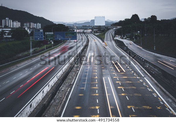 People busy commuting with cars using highway\
between cities.