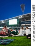 People came to the sports stadium to watch the match on the screen.