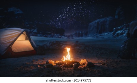 People Camping at Night in the Canyon, Preparing to Sleep in the Tent. Campfire Burning. Amazing Natural Landscape View with Marvelous Bright Milky Way Stars Shining on Mountains. - Powered by Shutterstock