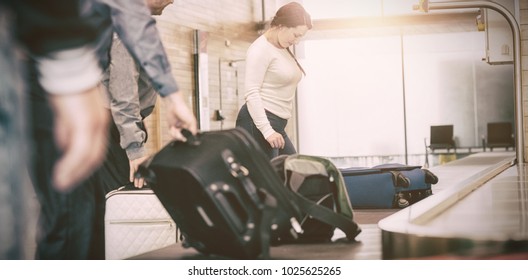 People Carrying Luggage From Baggage Claim At Airport