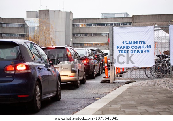 People in cars\
are queuing in front of a center coronavirus quick test center with\
sign saying 15-minute Rapid Covid-19 Test Drive In. Copenhagen,\
Denmark - December 21,\
2020.