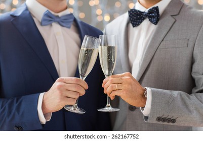 People, Celebration, Homosexuality, Same-sex Marriage And Love Concept - Close Up Of Happy Married Male Gay Couple Drinking Sparkling Wine On Wedding Over Holidays Lights Background