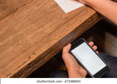 People Cheating On Test By Looking At Answer On Mobile Phone Under The Table