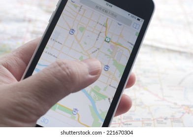 People checking smartphone with GPS navigator on map 