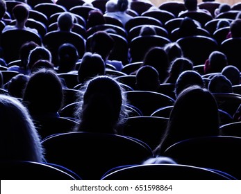 People, Children, Adults, Parents In The Theater Watching The Performance. People In The Auditorium Looking At The Stage. Shooting From The Back