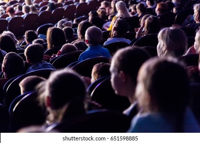 People, Children, Adults, Parents In The Theater Watching The Performance. People In The Auditorium Looking At The Stage. Shooting From The Back