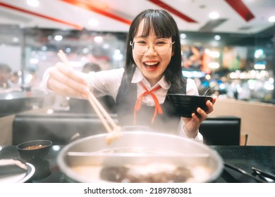 People City Break Enjoy Eating Food Lifestyle Concept. Happy Young Asian Woman In Japanese Uniform Student At Shabu Japan Sukiyaki Restaurant. Hot Pot With Smoke. Enjoy Foodie Tasty Time.