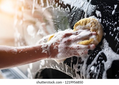 People Cleaning Car With Sponge At Car Wash