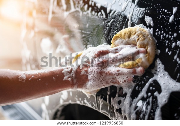 People cleaning car\
with sponge at car wash