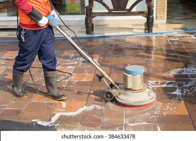 People Cleaning Floor With Machine