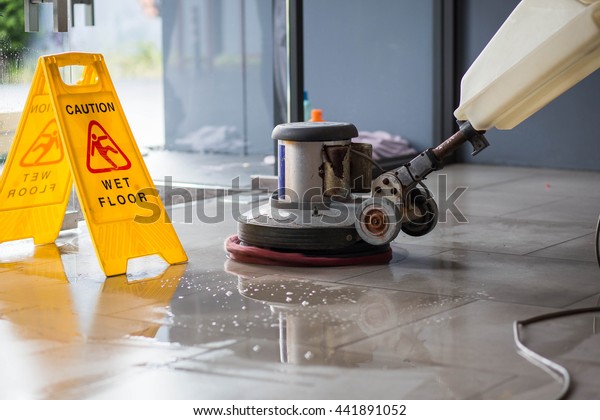 The people cleaning\
floor with machine.