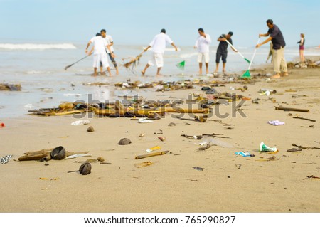People cleaning trashy polluted with garbage ocean beach. Bali island, Indonesia