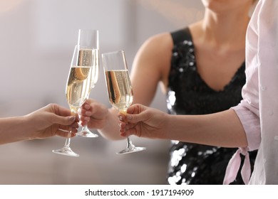 People clinking glasses of champagne against blurred background, closeup - Powered by Shutterstock