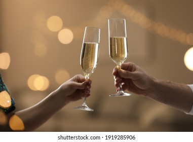 People clinking glasses of champagne against blurred background, closeup. Bokeh effect - Shutterstock ID 1919285906
